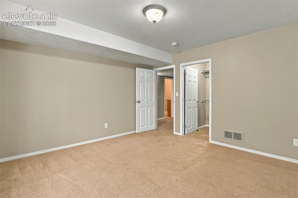 Image 38 of 50: Carpeted flooring, neutral wall tones, white trim, and a semi-flush mount c