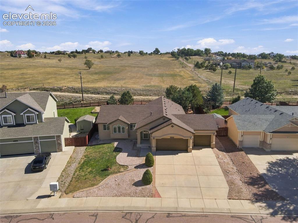 Image 42 of 50: Single-story property with an attached two-car garage, a paved driveway, an