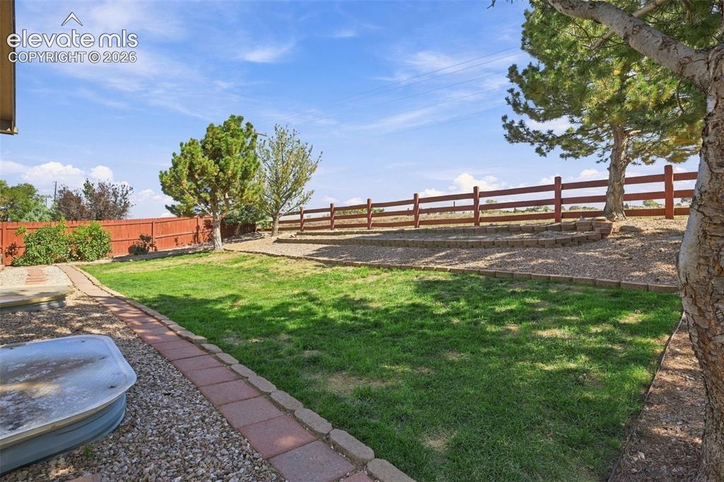 Image 47 of 50: Expansive outdoor space featuring a manicured lawn, established trees, and 