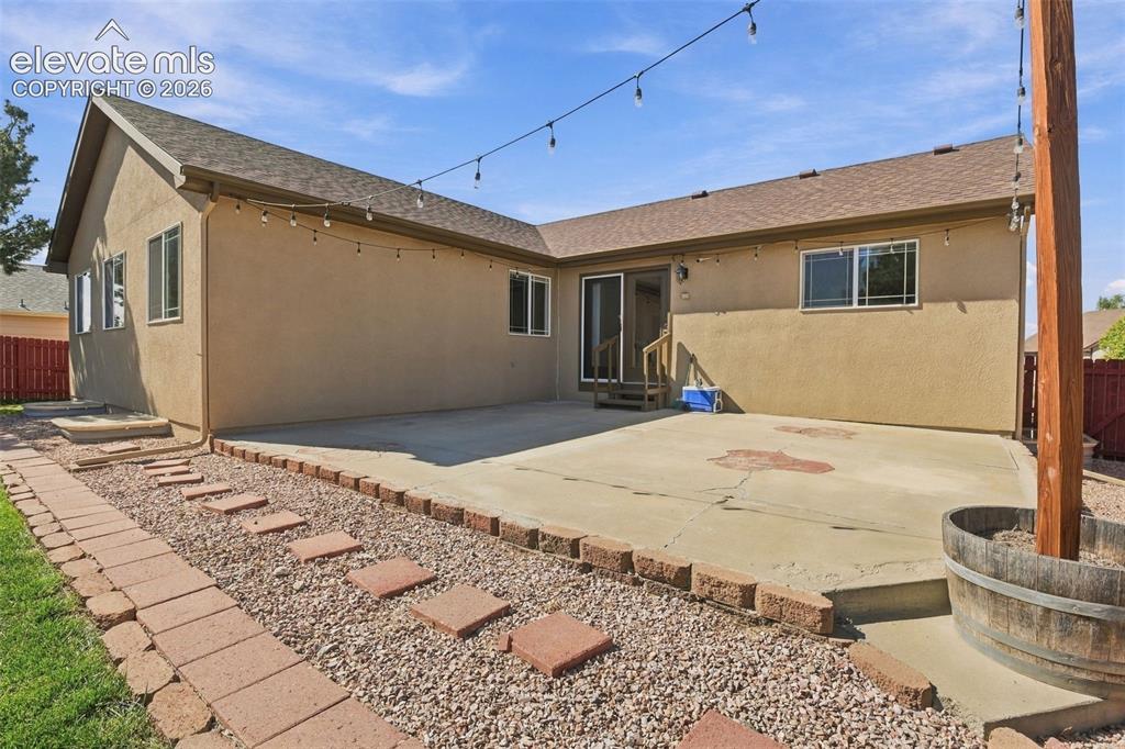 Image 50 of 50: Expansive concrete patio with sliding glass door access