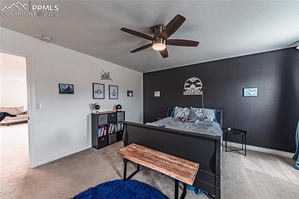 Image 33 of 49: Carpeted bedroom with baseboards and a ceiling fan