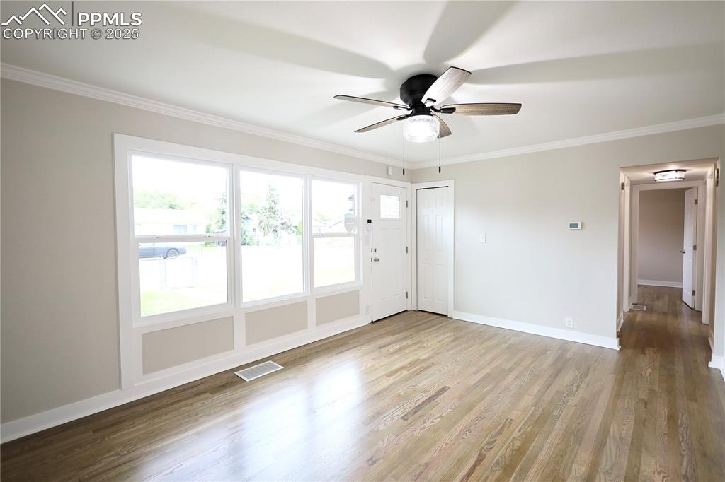 Image 10 of 27: Spare room featuring ornamental molding, wood finished floors, and ceiling