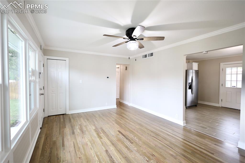Image 11 of 27: Spare room with ornamental molding, light wood-style floors, and a ceiling