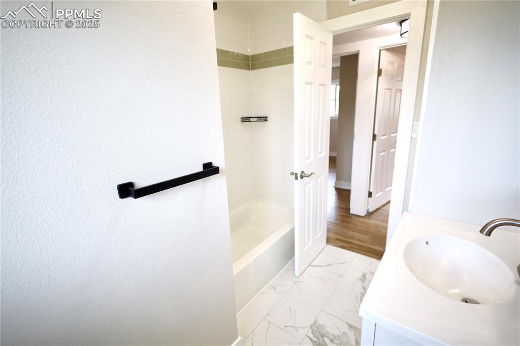 Image 13 of 27: Full bathroom featuring vanity, bathing tub / shower combination, and light