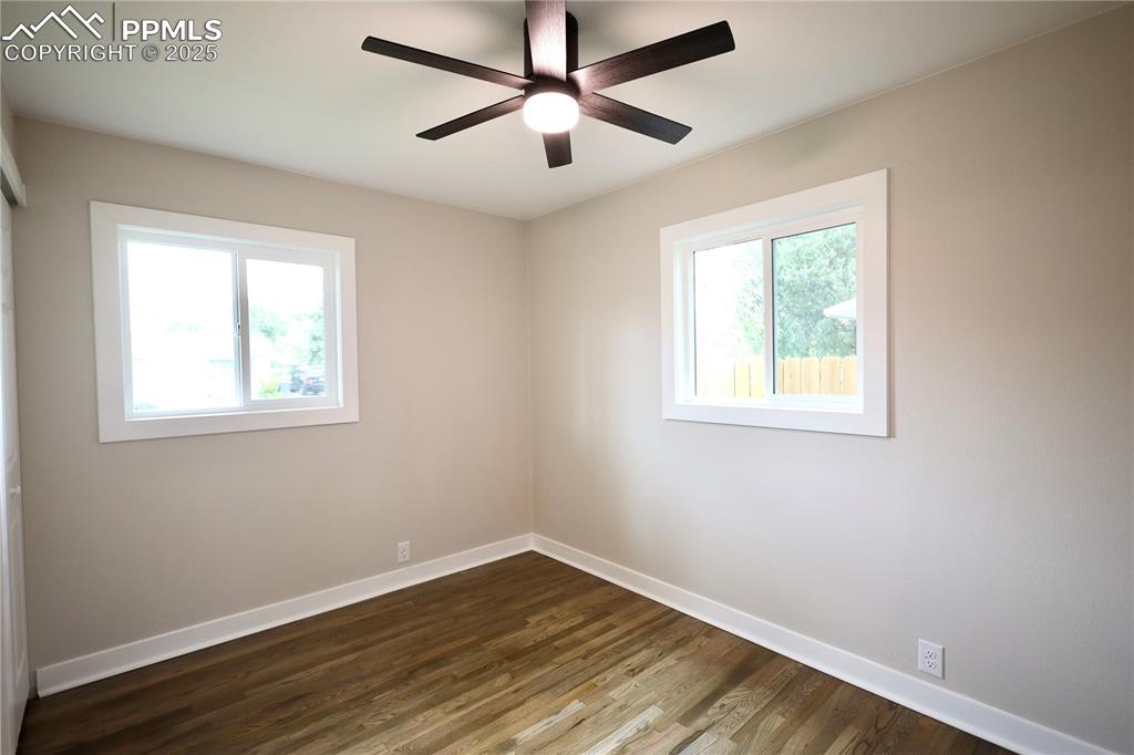 Image 19 of 27: Unfurnished room with dark wood-style floors and a ceiling fan