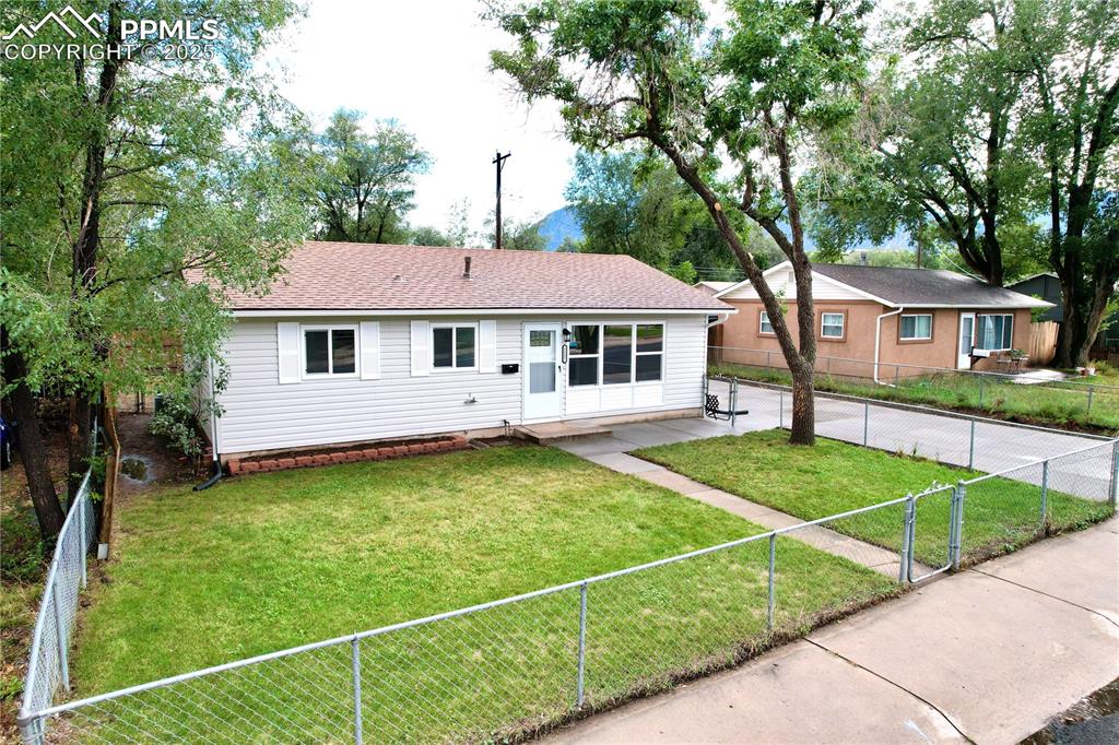 Image 2 of 27: Ranch-style house with a fenced backyard and roof with shingles