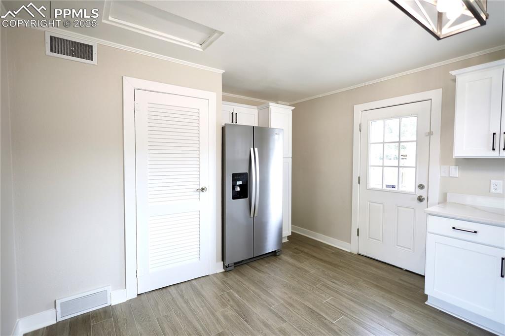Image 7 of 27: Kitchen with stainless steel refrigerator with ice dispenser, white cabinet