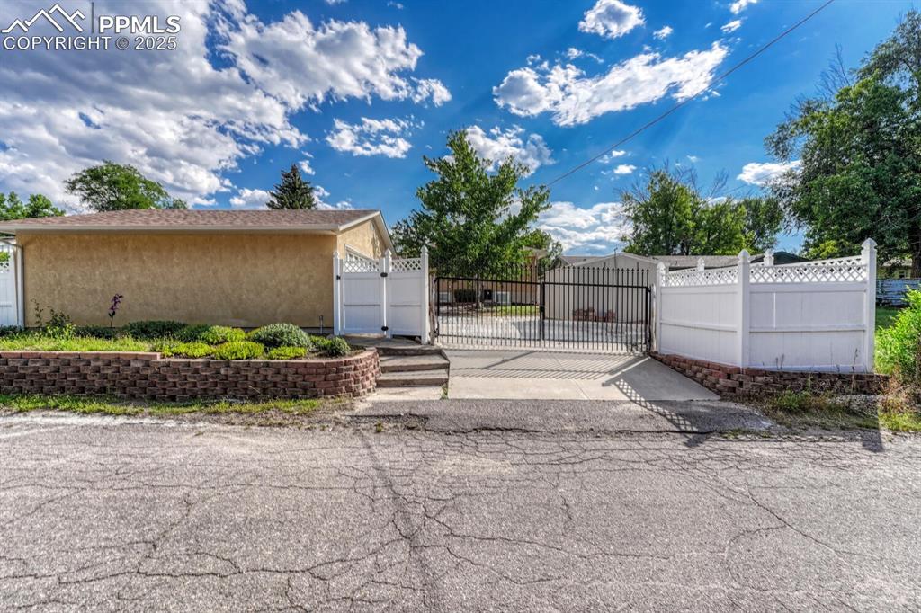 Image 41 of 50: View from alley showing gate, detached garage, and shed