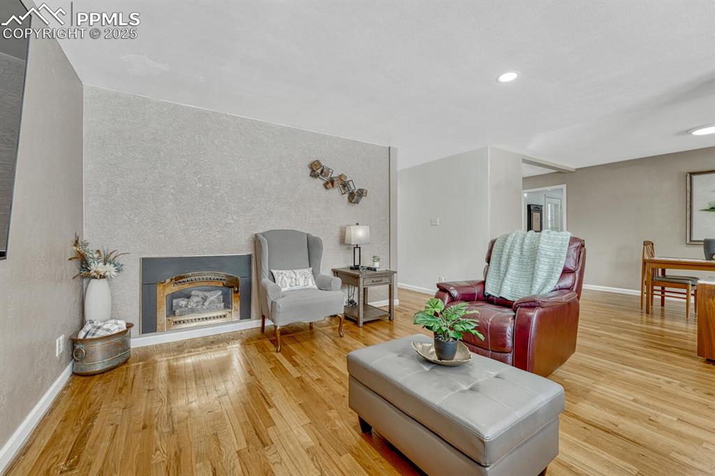 Image 9 of 50: Gas fireplace and wood floor in living room