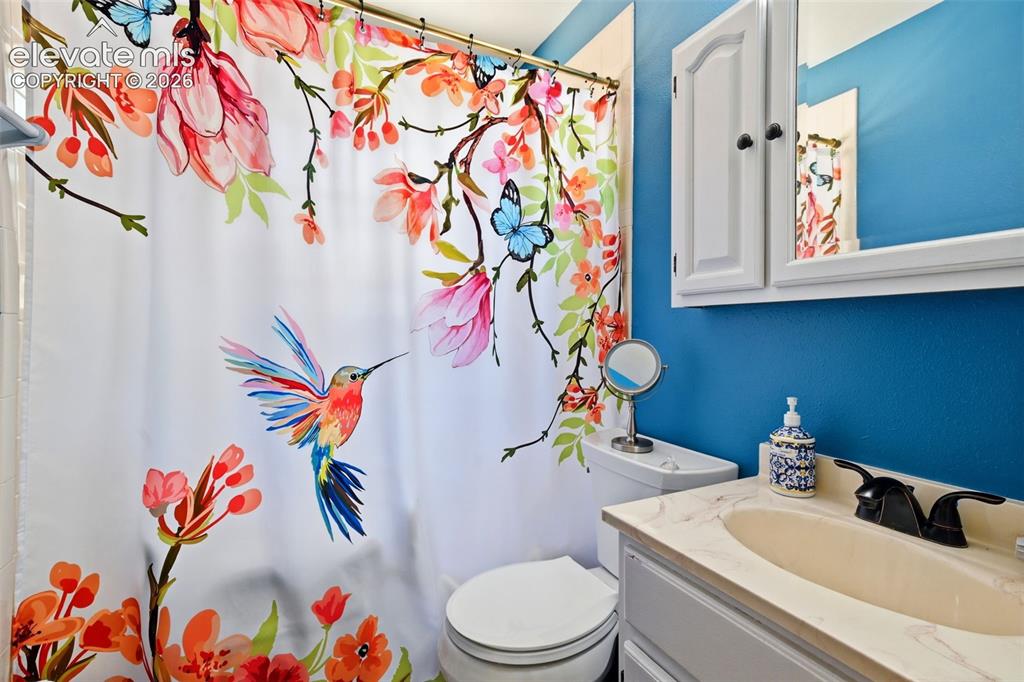 Image 30 of 50: Bathroom featuring a single vanity with an integrated sink, a medicine cabi