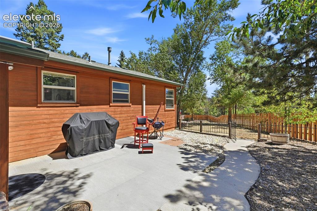 Image 38 of 50: Concrete patio with wood-sided exterior and a fenced-in yard