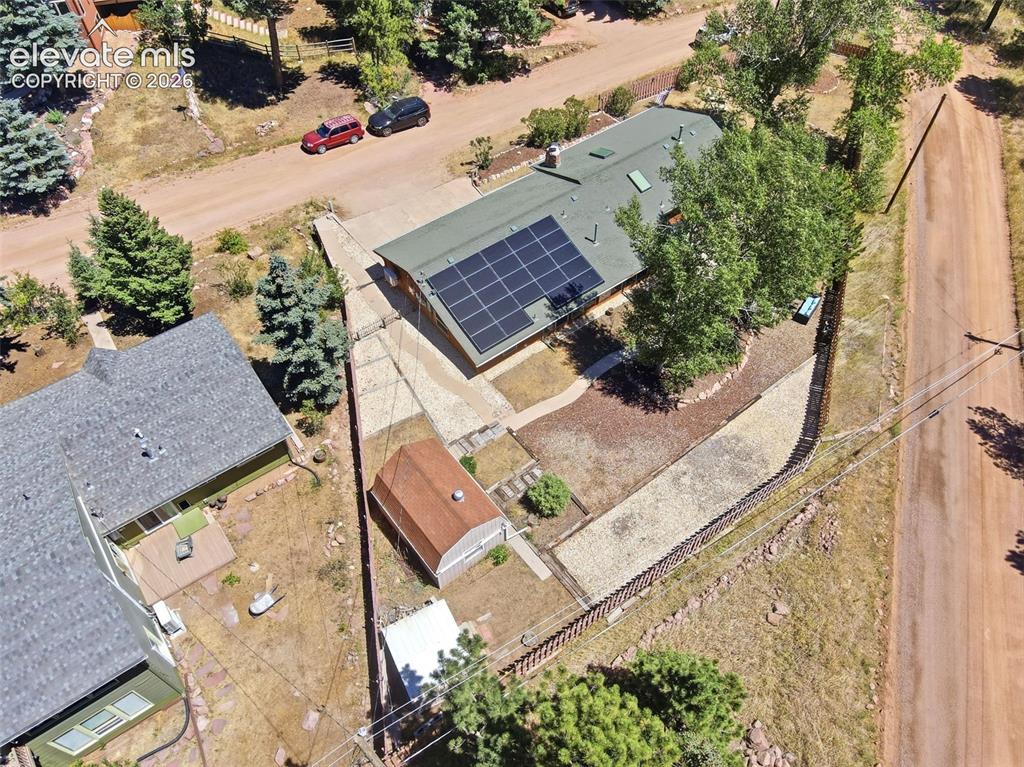 Image 45 of 50: Ranch-style residence featuring solar panels on the roof, a concrete drivew