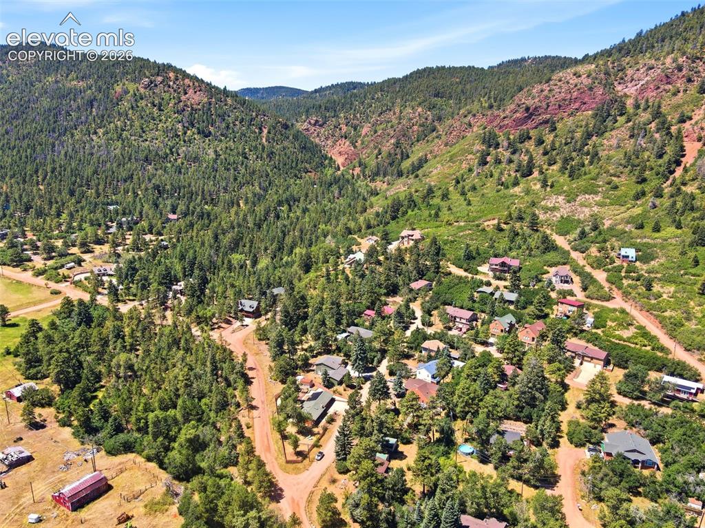 Image 46 of 50: Expansive mountain landscape featuring a community of homes nestled among d