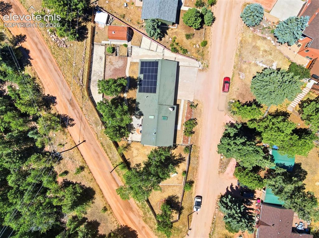 Image 48 of 50: Property featuring a green roof, solar panel array, and a surrounding natur