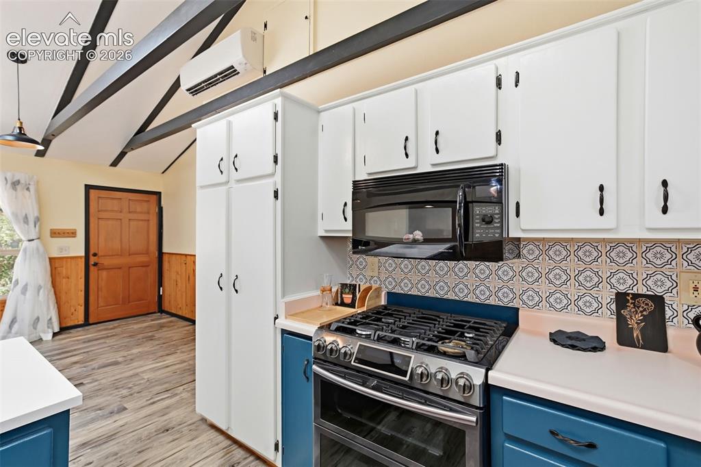Image 8 of 50: Kitchen featuring white upper cabinetry, blue lower cabinetry, patterned ti