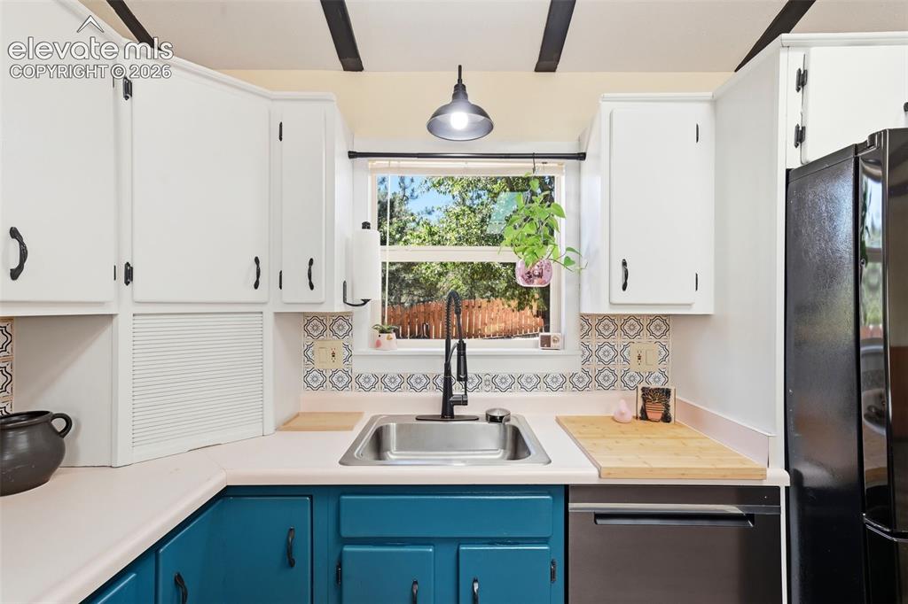 Image 9 of 50: Kitchen featuring a stainless steel sink with a matte black faucet, white u