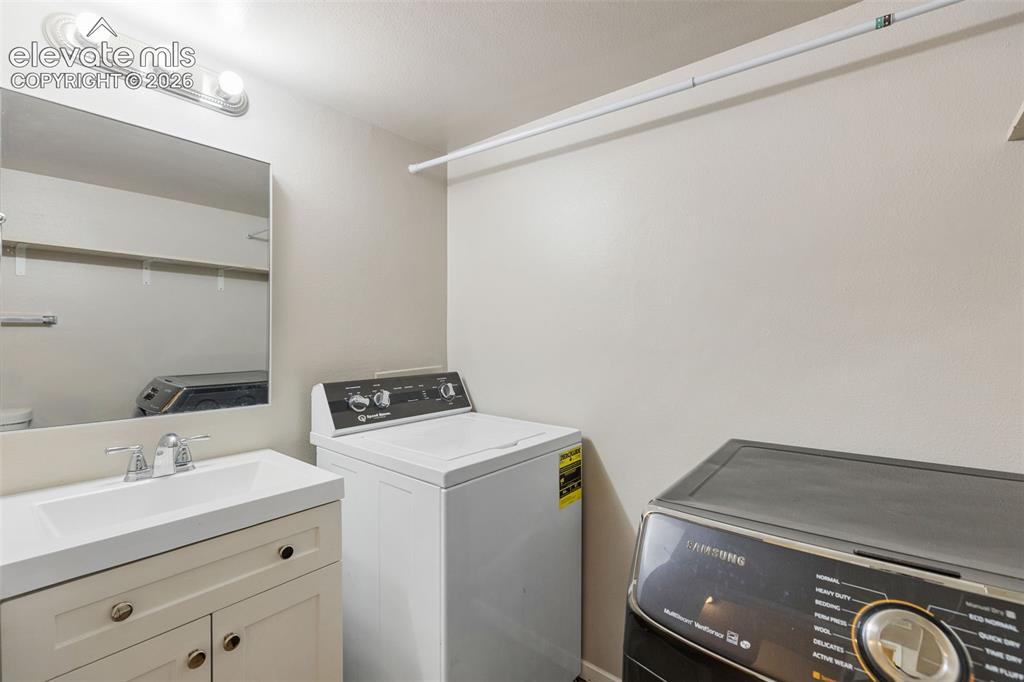 Image 12 of 28: Main-level half bathroom and laundry area