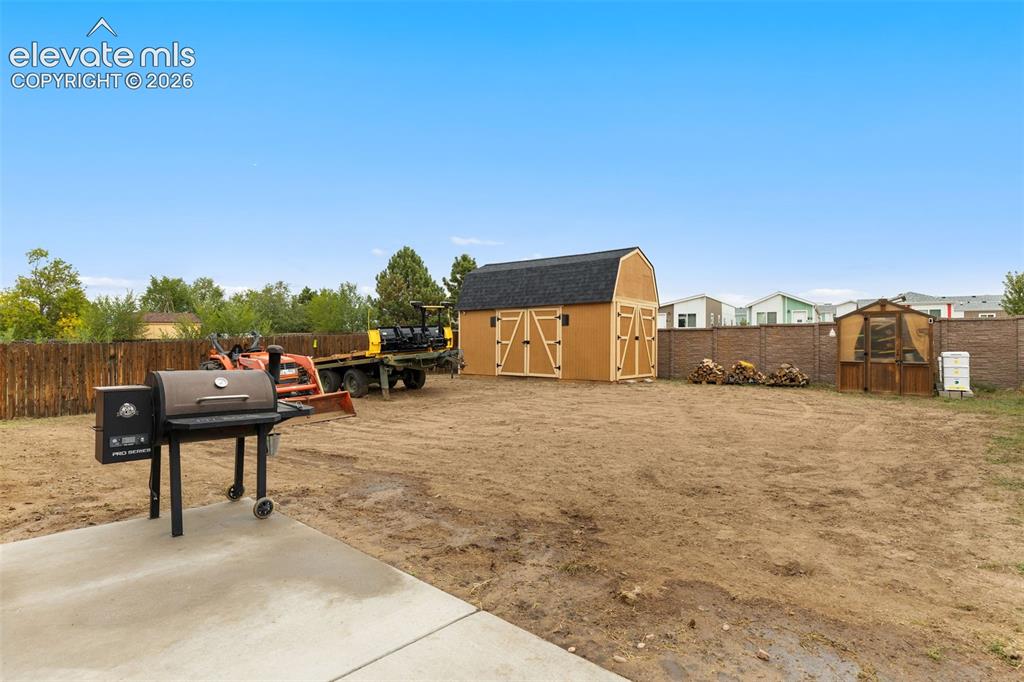 Image 18 of 28: The expansive backyard features a massive storage shed and greenhouse, perf