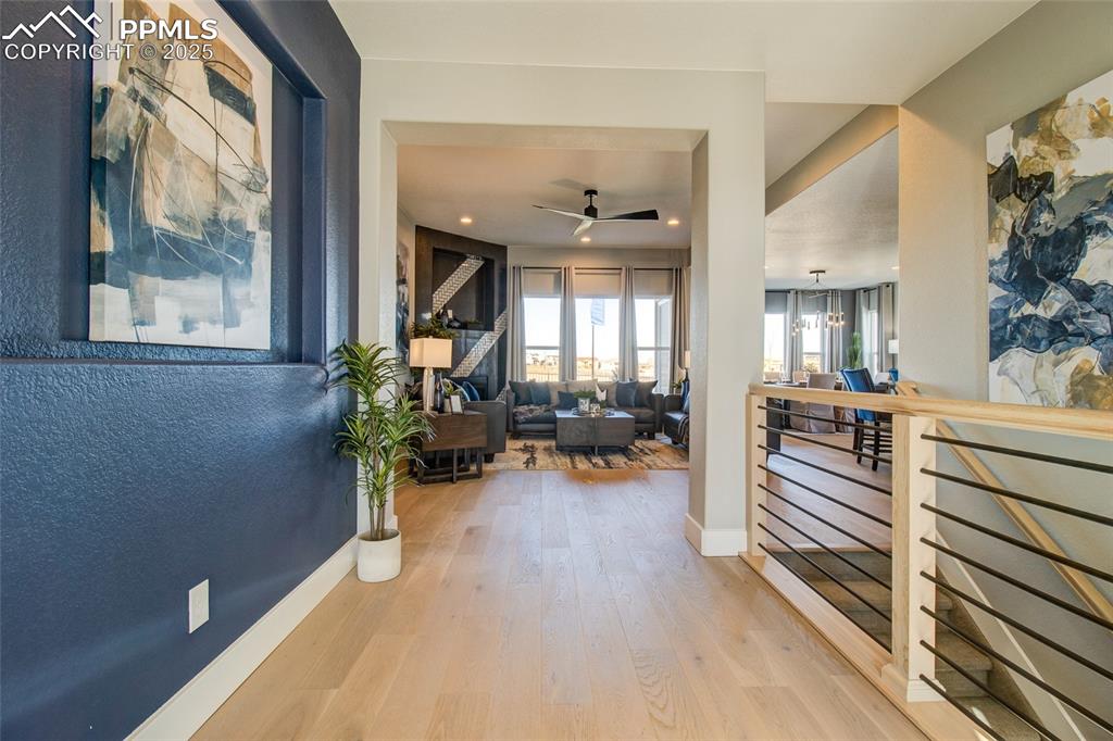 Image 3 of 30: Corridor with an upstairs landing and wood finished floors