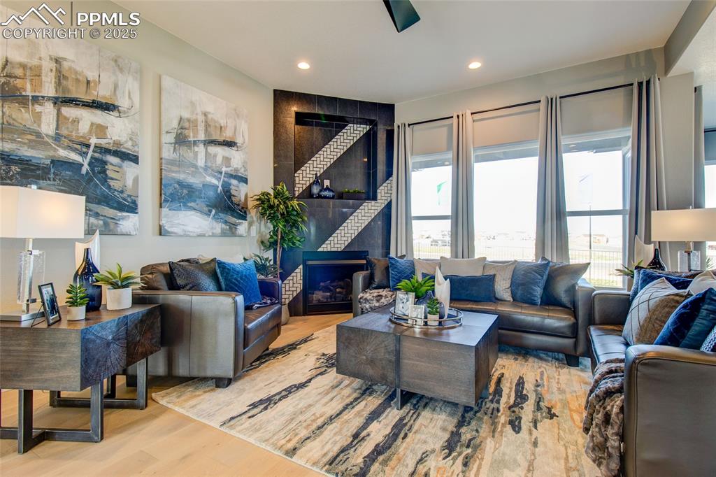 Image 5 of 30: Living area with wood finished floors, recessed lighting, and a fireplace