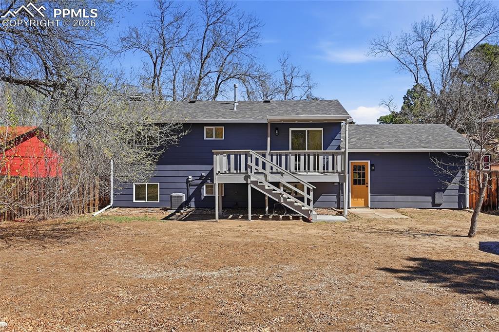 Image 20 of 26: Rear view of property with a shingled roof and a wooden deck