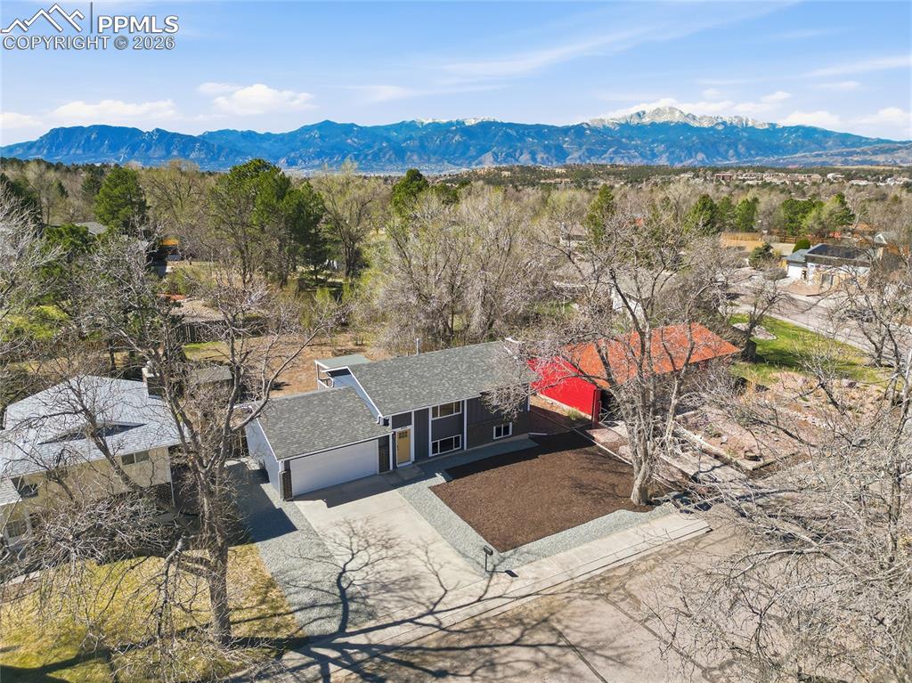 Image 21 of 26: View from above of property with a mountainous background