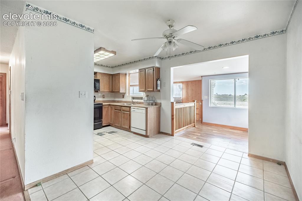 Image 10 of 50: Kitchen featuring wood cabinetry, a built-in dishwasher, and tile flooring