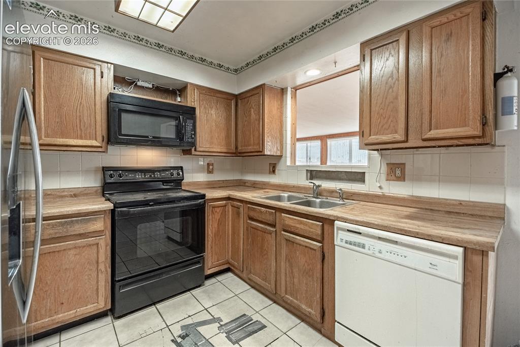 Image 13 of 50: Kitchen featuring wood-finish cabinetry, white tile backsplash, and integra