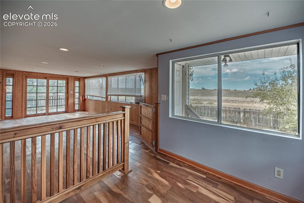 Image 16 of 50: Wood-finish flooring, natural wood paneling, sliding glass doors, and reces