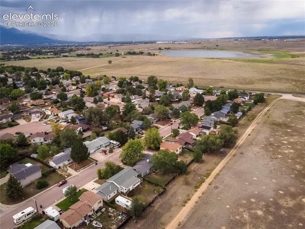 Image 2 of 50: Residential neighborhood with mature trees, adjacent to expansive open land