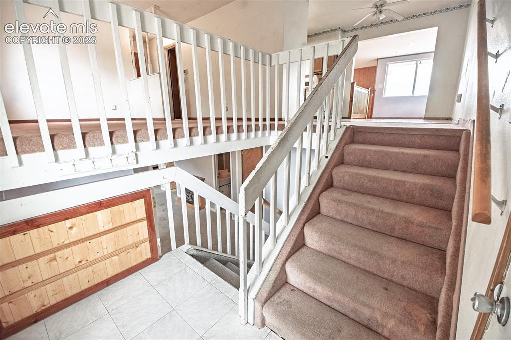 Image 28 of 50: Multi-level interior featuring tiered staircases, carpeted stairs, and whit