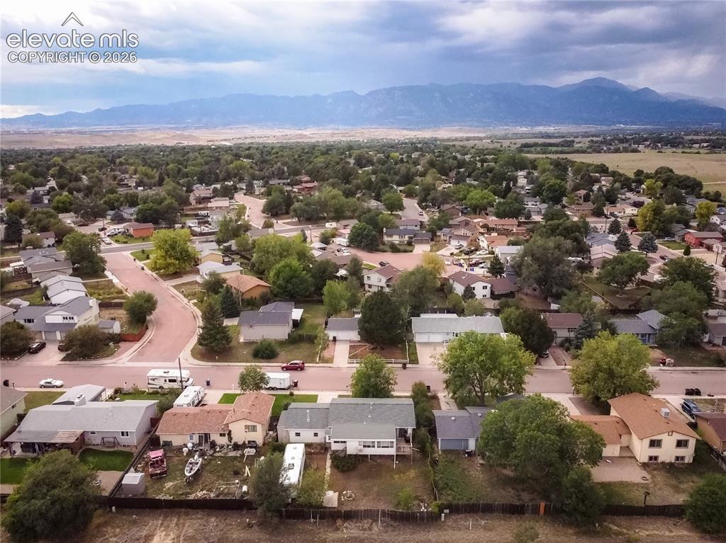 Image 49 of 50: Residential neighborhood with mature trees and mountain backdrop
