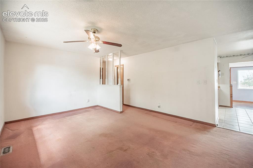Image 7 of 50: Textured ceiling with a ceiling fan light fixture