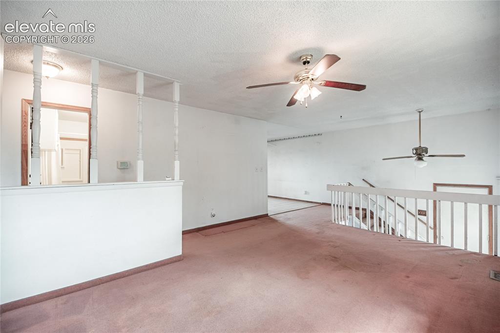 Image 8 of 50: Carpeted living area with white walls and ceiling