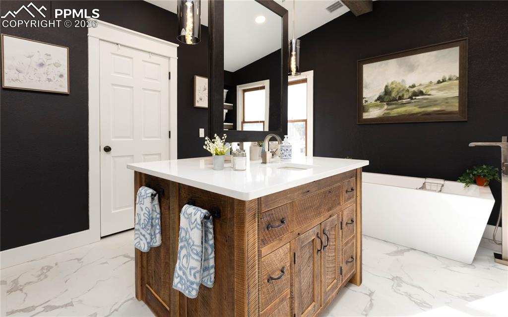 Image 10 of 42: Beautifully redone primary bathroom has 2 large closets, shower and a tub