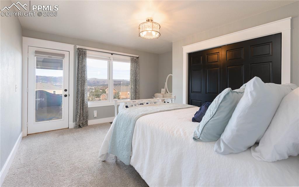 Image 17 of 42: Main-level bedroom walks out to back deck with lovely view of the mountains