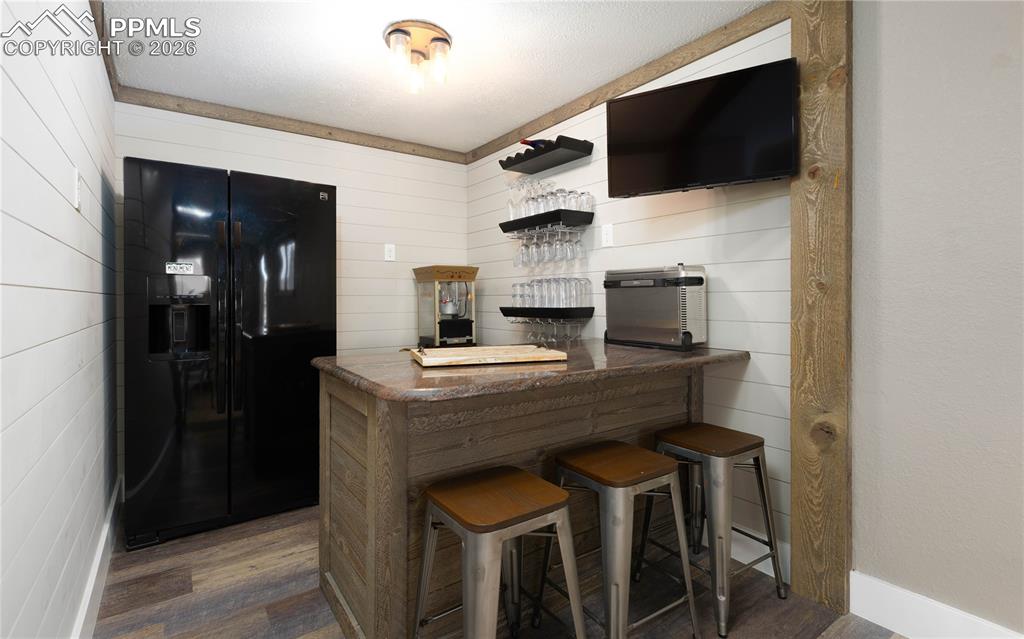 Image 23 of 42: Basement bar area with full-size refrigerator