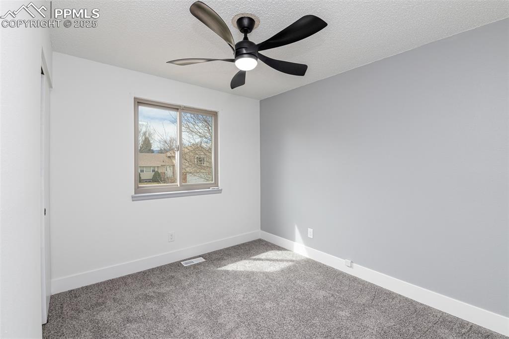 Image 17 of 33: Empty room with baseboards, visible vents, carpet, and a textured ceiling