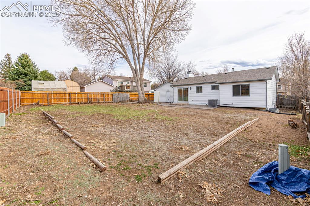 Image 30 of 33: View of yard with a fenced backyard and central air condition unit