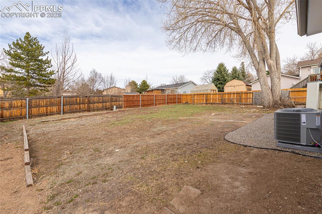 Image 31 of 33: View of yard with central AC unit and a fenced backyard