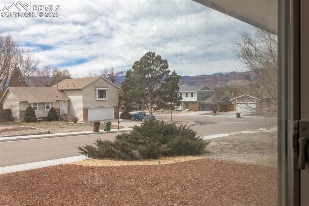 Image 8 of 33: View of yard featuring driveway, a garage, and a residential view