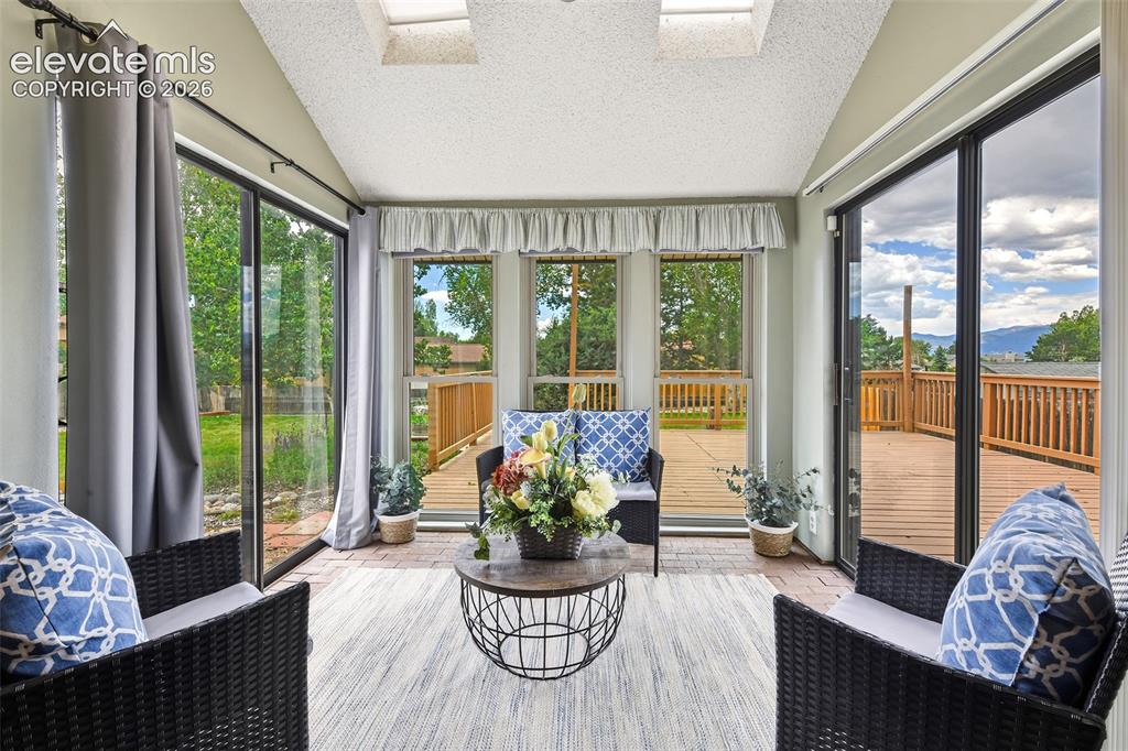Image 9 of 45: Fabulous sunroom with brick flooring and double sliding glass doors