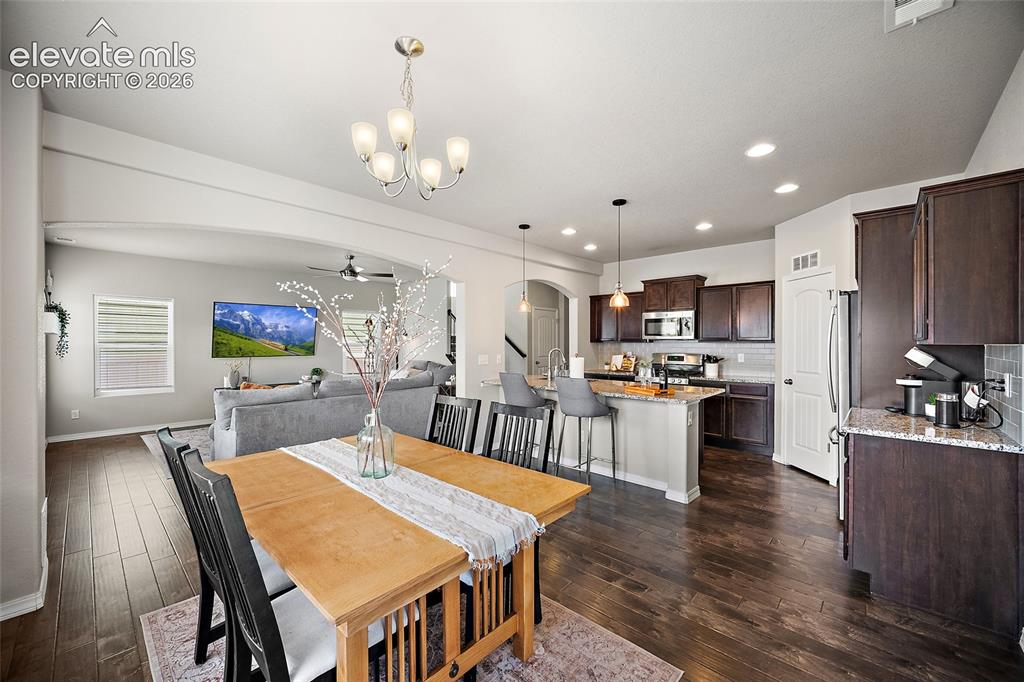 Image 10 of 49: Open-concept layout featuring wood-finish flooring, a kitchen island with s