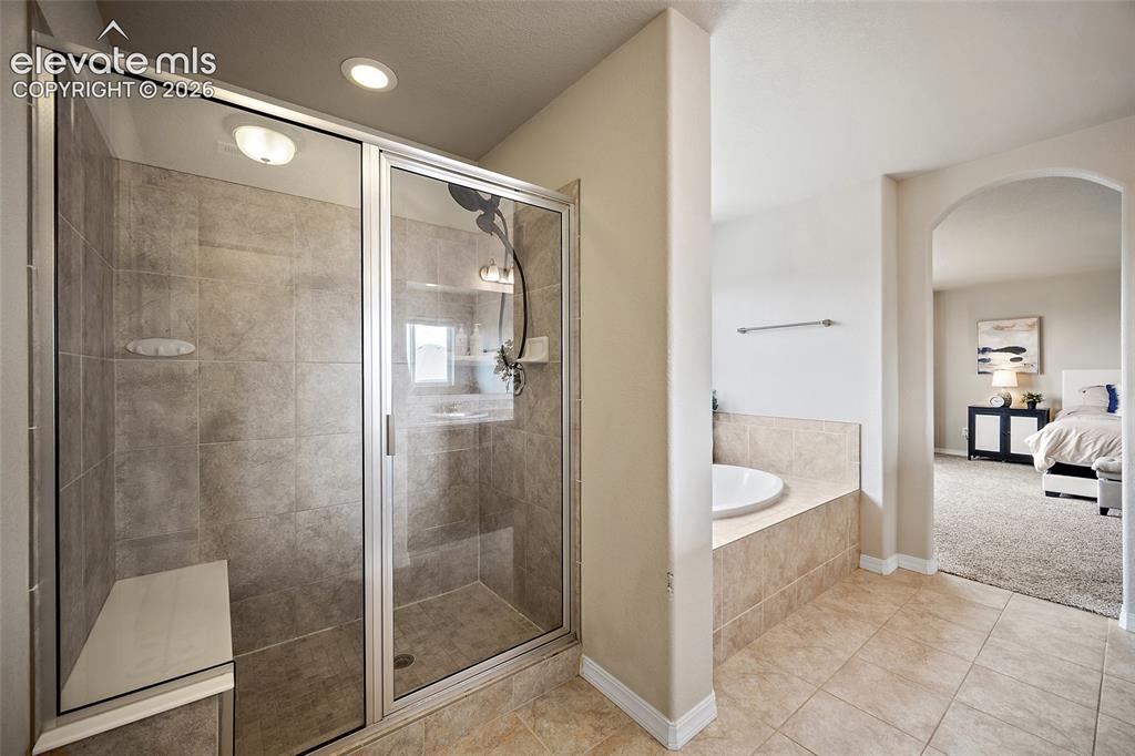Image 25 of 49: Spacious walk-in shower featuring glass enclosure with brushed nickel accen