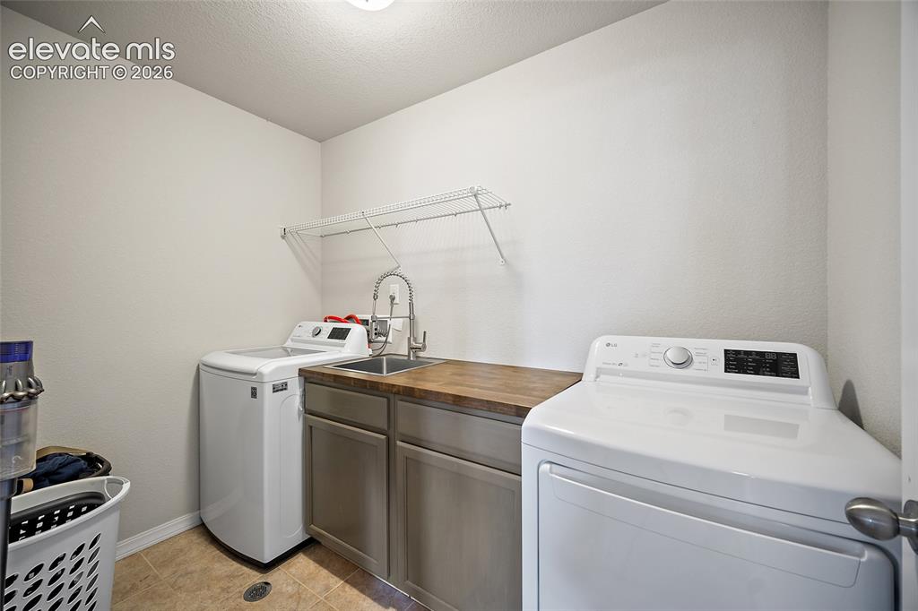 Image 27 of 49: Dedicated laundry space featuring a utility sink with a high-arc faucet, wo