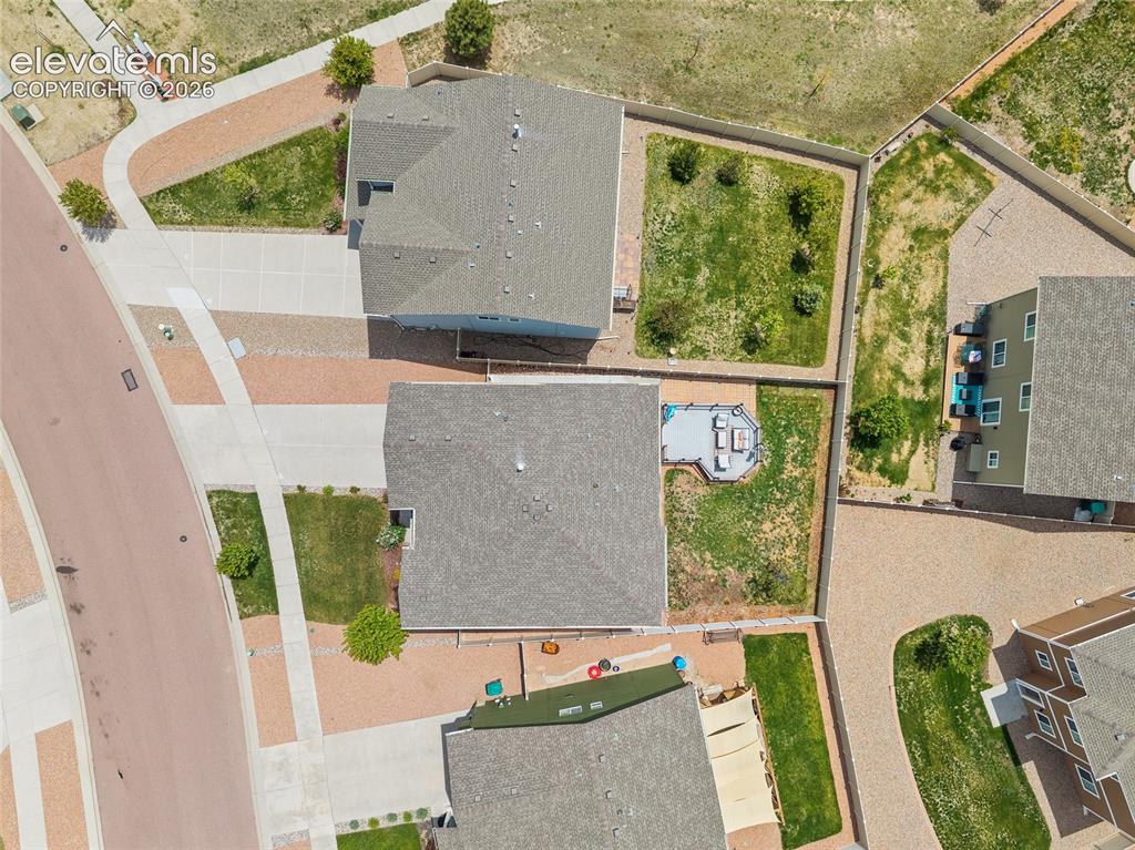 Image 42 of 49: Aerial view highlighting a residential property with a shingled roof and a 