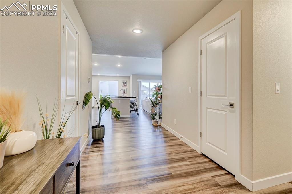 Image 2 of 19: Hallway featuring recessed lighting, light wood-type flooring, a sink, and