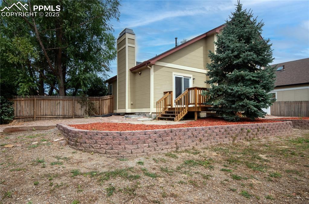 Image 3 of 41: Back of house featuring a fenced backyard, a patio, a chimney, and a deck