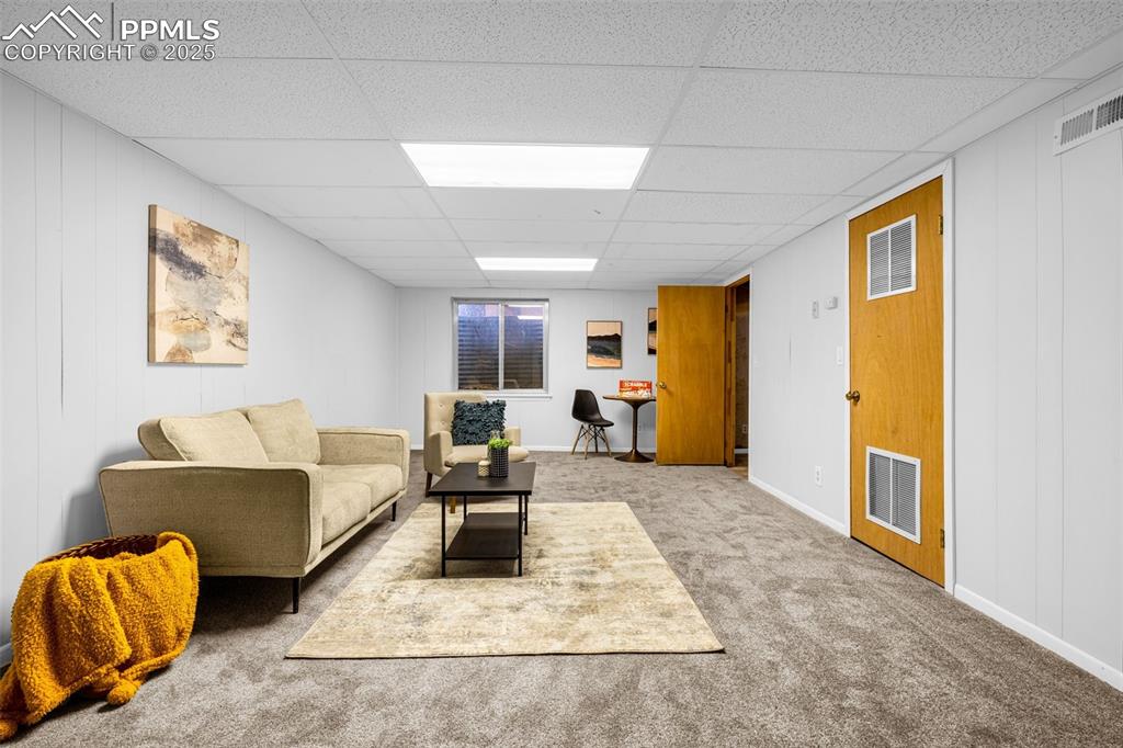 Image 26 of 40: Carpeted living room featuring a paneled ceiling