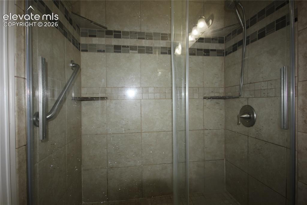 Image 23 of 33: Large walk in shower with tile surrounding